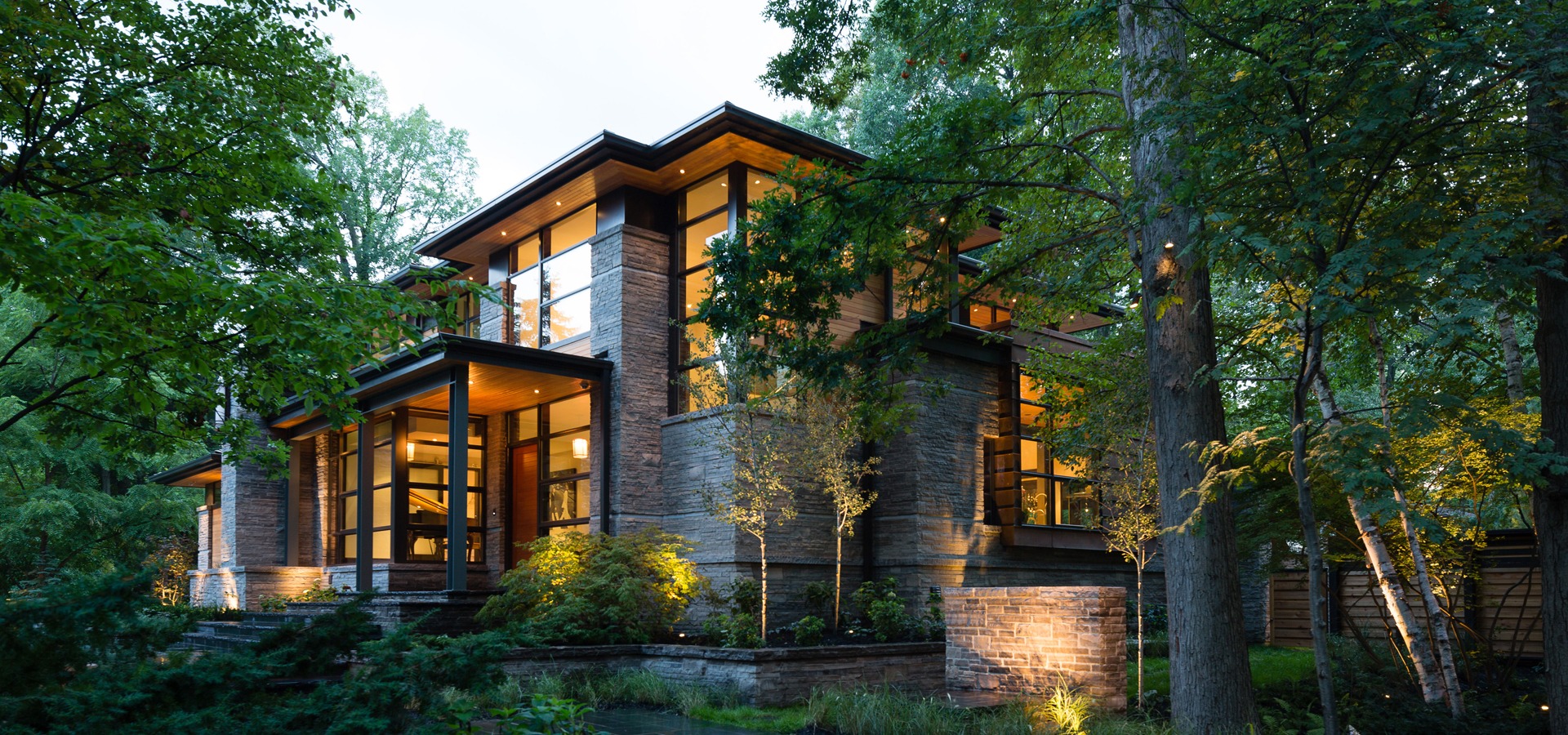 Modern house with steel beams, wood soffit and black frame windows.