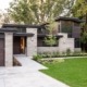 Modern bungalow with natural stone, flat roof and black frame windows.