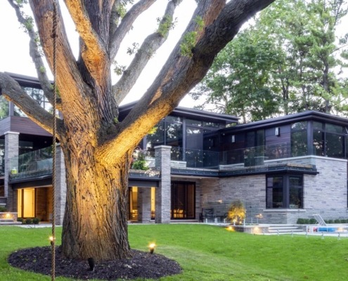 Contemporary home with flat roof, stone columns and wall sconce.