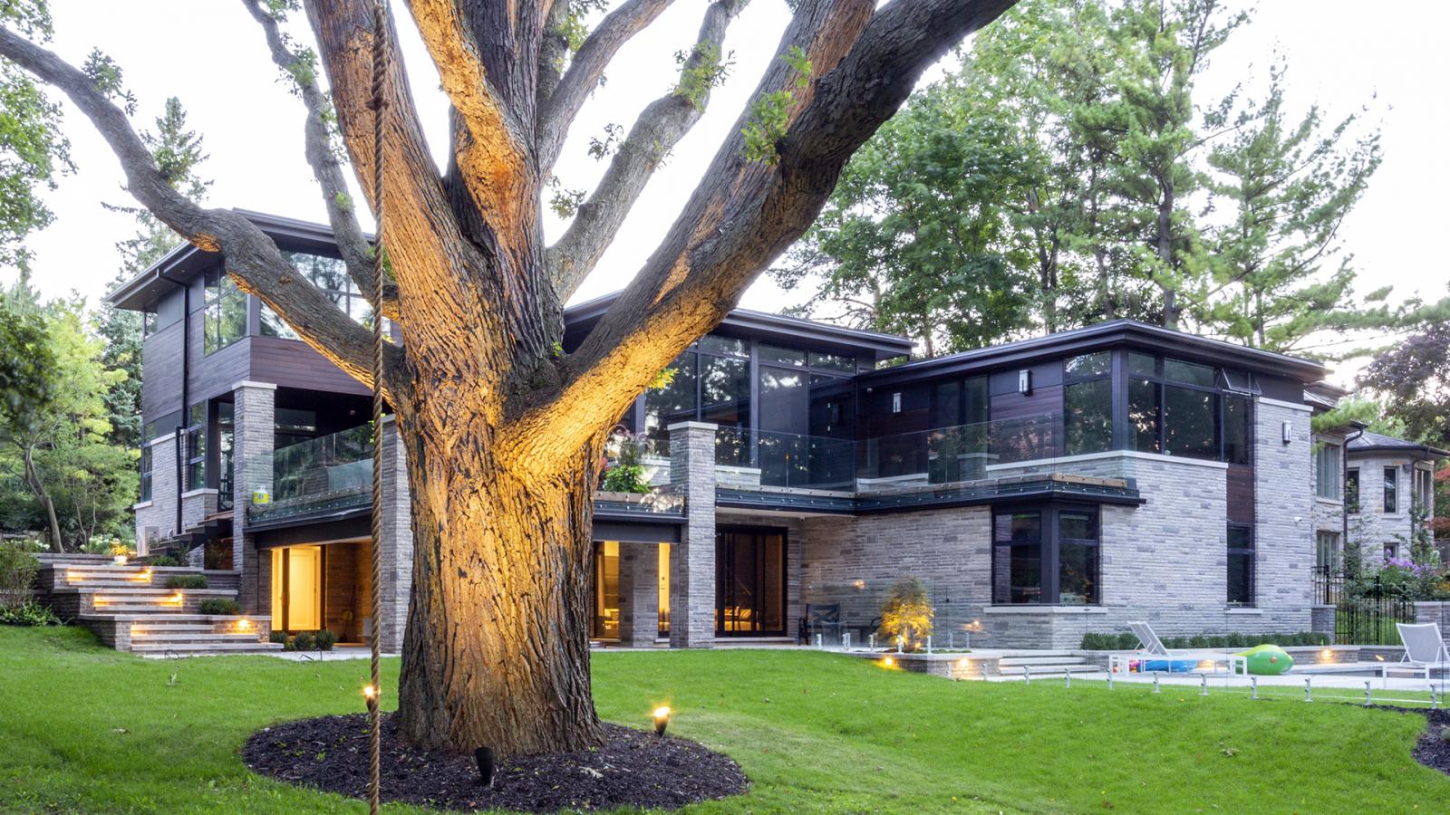 Contemporary home with flat roof, stone columns and wall sconce.