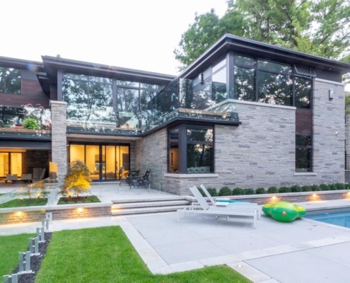 Natural modern home with stone siding, wood siding and large balcony.