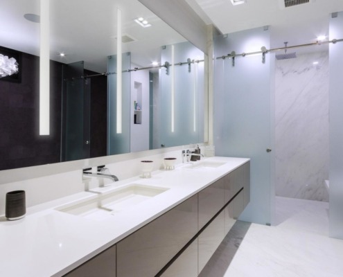 Large bathroom with floating vanity, white tile and frosted glass.