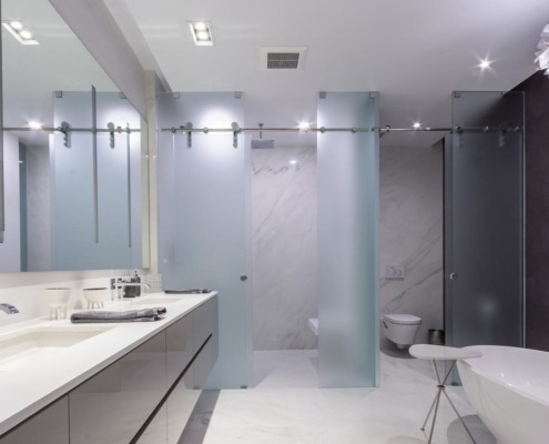 Master bathroom with double sink, tile floor and freestanding tub.