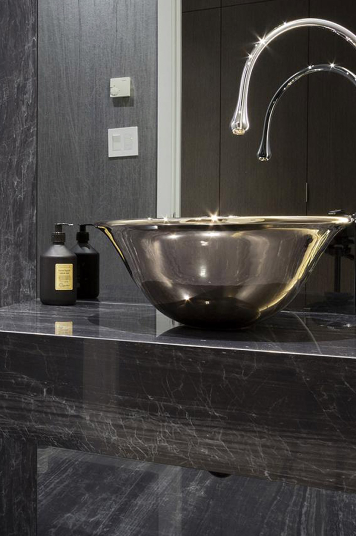 Half bath with bowl sink, black wallpaper and black counter.