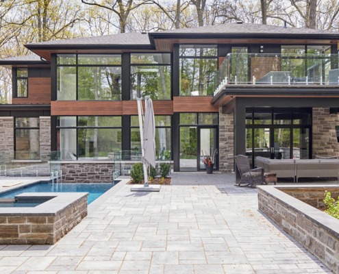 Contemporary home with floating roof, wood siding and second floor balcony.