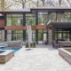 Contemporary home with floating roof, wood siding and second floor balcony.