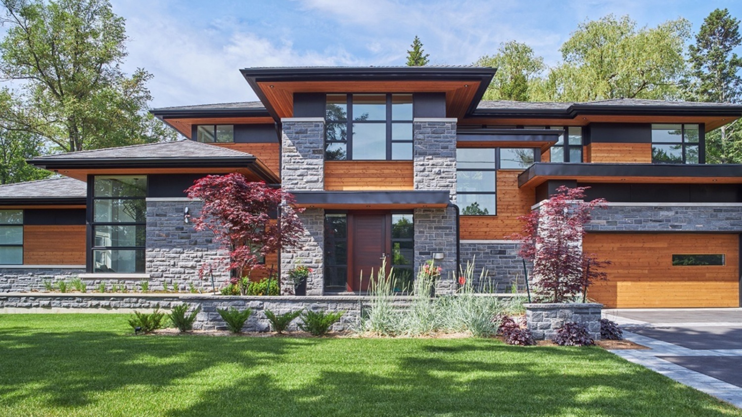 Modern home with wood front door, corner windows and floating roof.