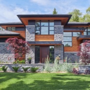 Modern home with wood front door, corner windows and floating roof.