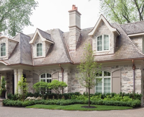 Traditional home front entry with white column, wood front door and flagstone walkway.