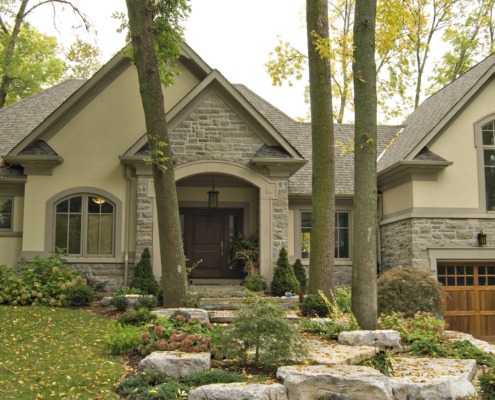 Mississauga renovation with stucco siding, wood garage door and arched windows.