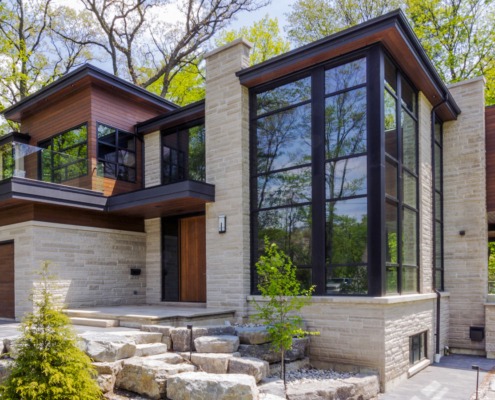 Mississauga house with stone columns, wood front door and wall sconce.