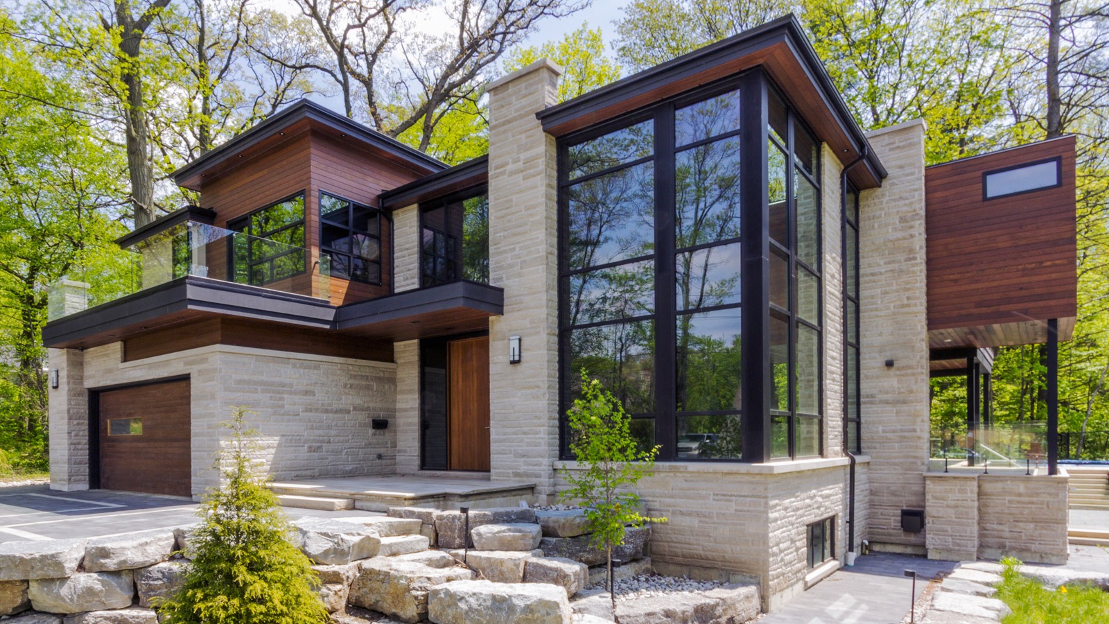 Mississauga house with stone columns, wood front door and wall sconce.