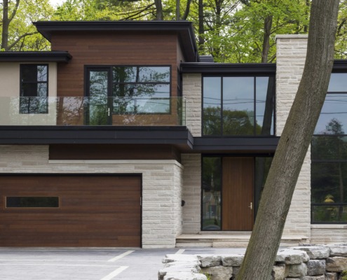 Natural modern home with wood garage door, stucco siding and natural stone.