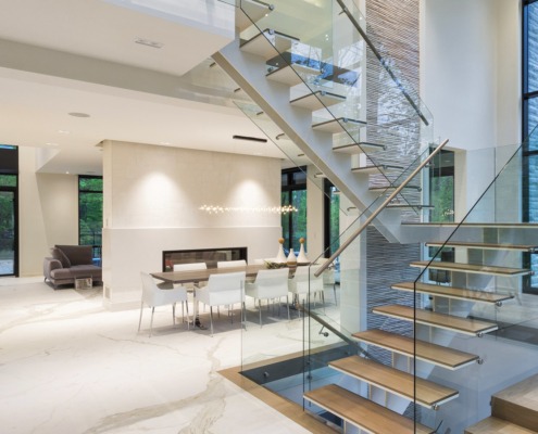 Open concept home with marble floor, floating stair and white walls.