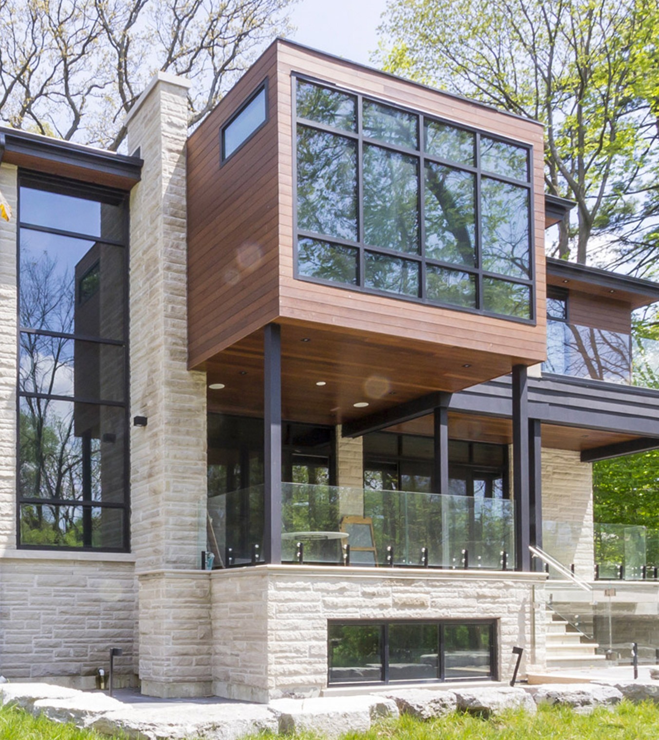 Modern house with floor to ceiling windows, covered porch and cantilevered room.
