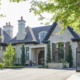 Luxury home with natural stone, iron gate and wood shutters.