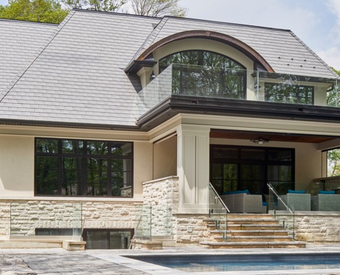 Mississauga home with stucco siding, second floor balcony and arched window.