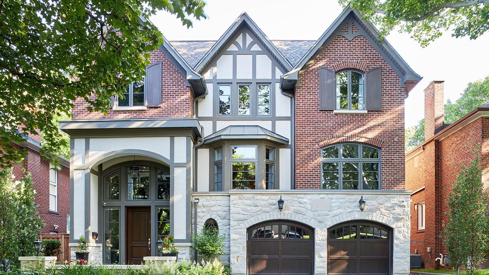 Toronto house with red brick, gray trim and white stucco.