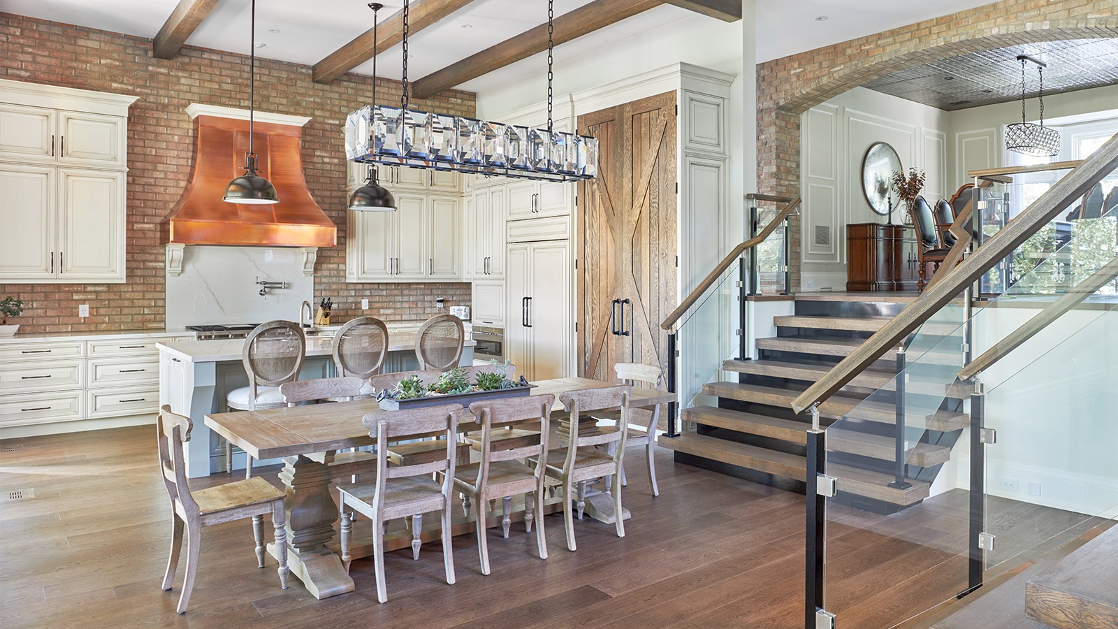 Kitchen with wood barn door, wood dining table and high ceilings.