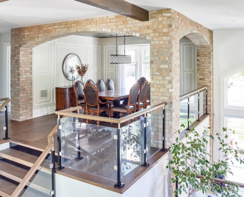Elevated dining room with wood dining table, exposed brick and white trim.