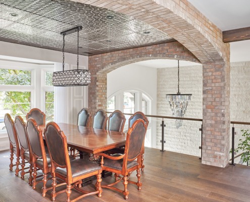 Dining room with exposed brick, hardwood floor and white frame window.