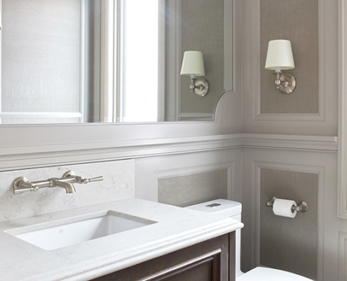 Bathroom with hardwood floor, floating vanity and gray wallpaper.
