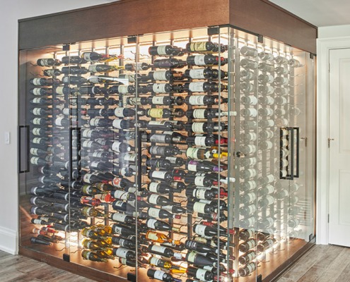 Glass wine cellar with hardwood floor and white baseboard.