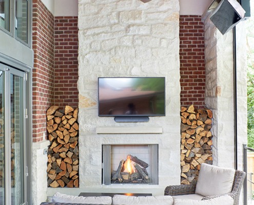 Backyard with hardwood floor, exposed brick and outdoor fireplace.