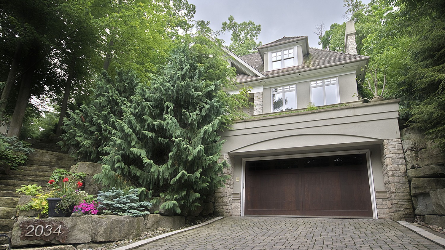 Custom home with natural stone, white frame windows and stone steps.