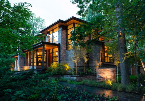 Natural modern home with flat roof, wood soffit and corner windows.