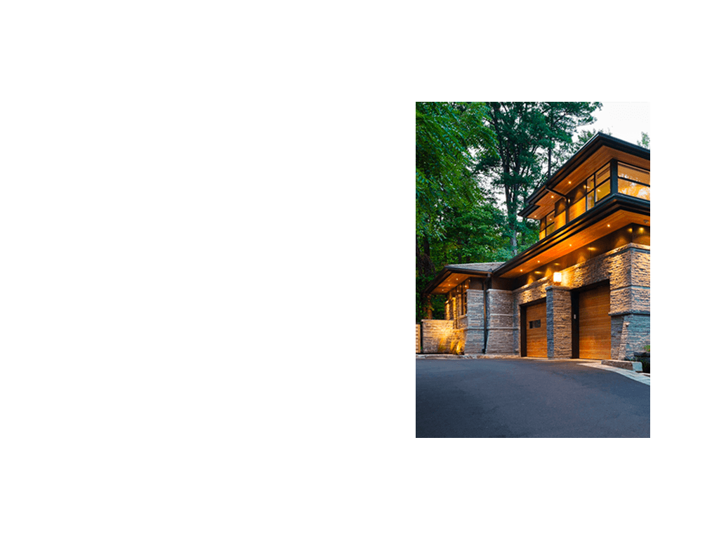 Contemporary custom home with wood soffit, stone wall and black trim.