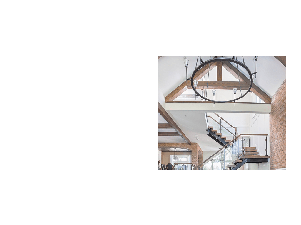 Modern floating staircase with wood treads, glass railing and wood beams.