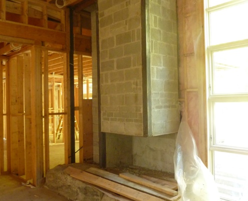 Construction of floating fireplace with large boulder.