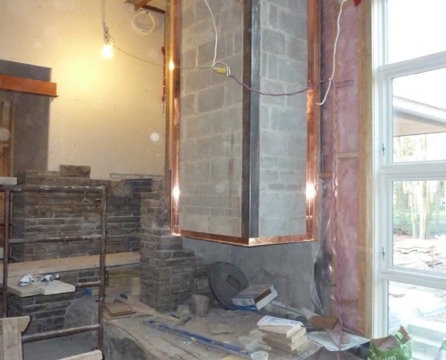 Building of fireplace and stone wall for modern family room.