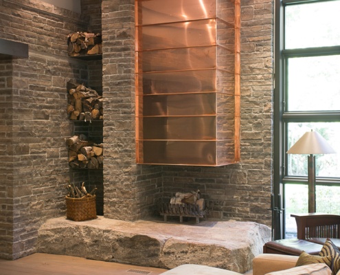 Modern living room with floating fireplace, built in storage and stone slab.