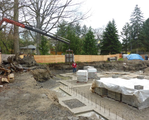 Crane moving concrete blocks on construction site.