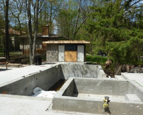 Construction of concrete swimming pool, spa, and patio in progress.