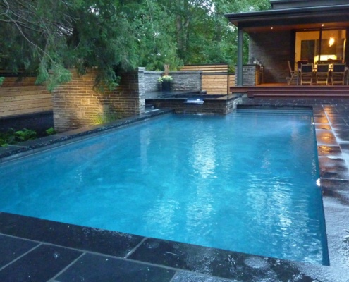 Modern inground pool and hot tub with flag stone walkway.