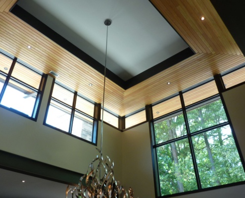 Modern vaulted ceiling with large black frame windows.